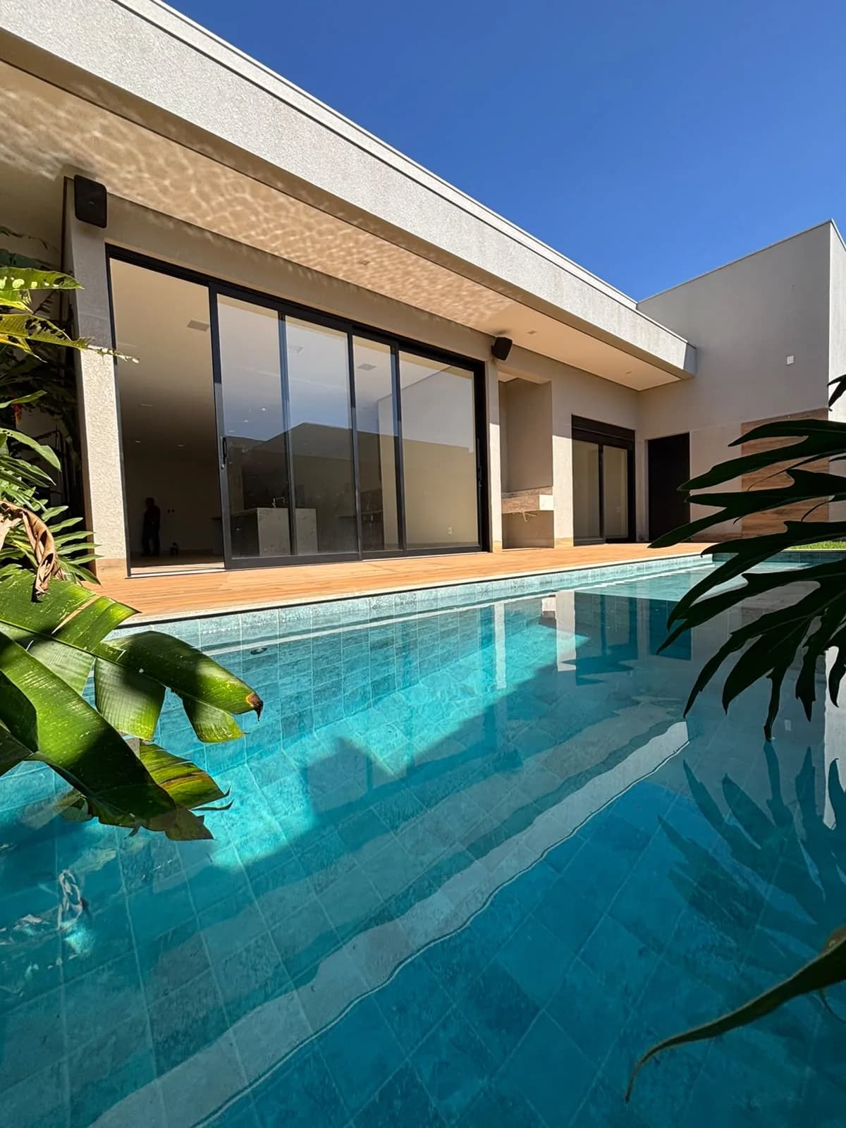 Piscina integrada ao espaço gourmet da casa